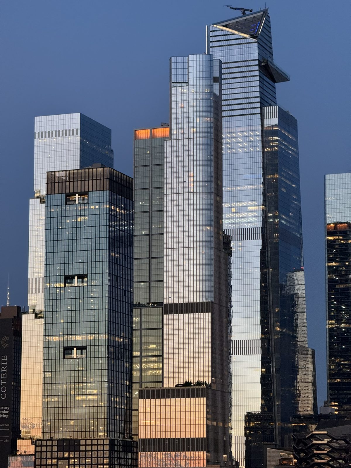 Glass towers at dusk with warm light on their upper floors