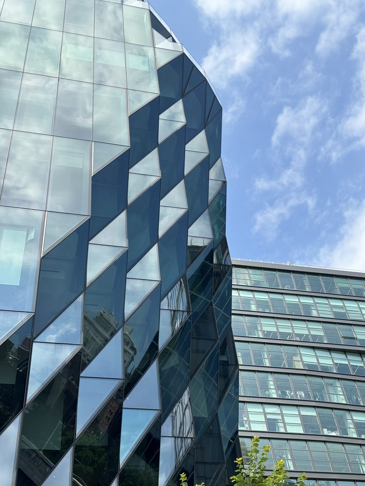 A glass facade with a diamond pattern under a blue sky