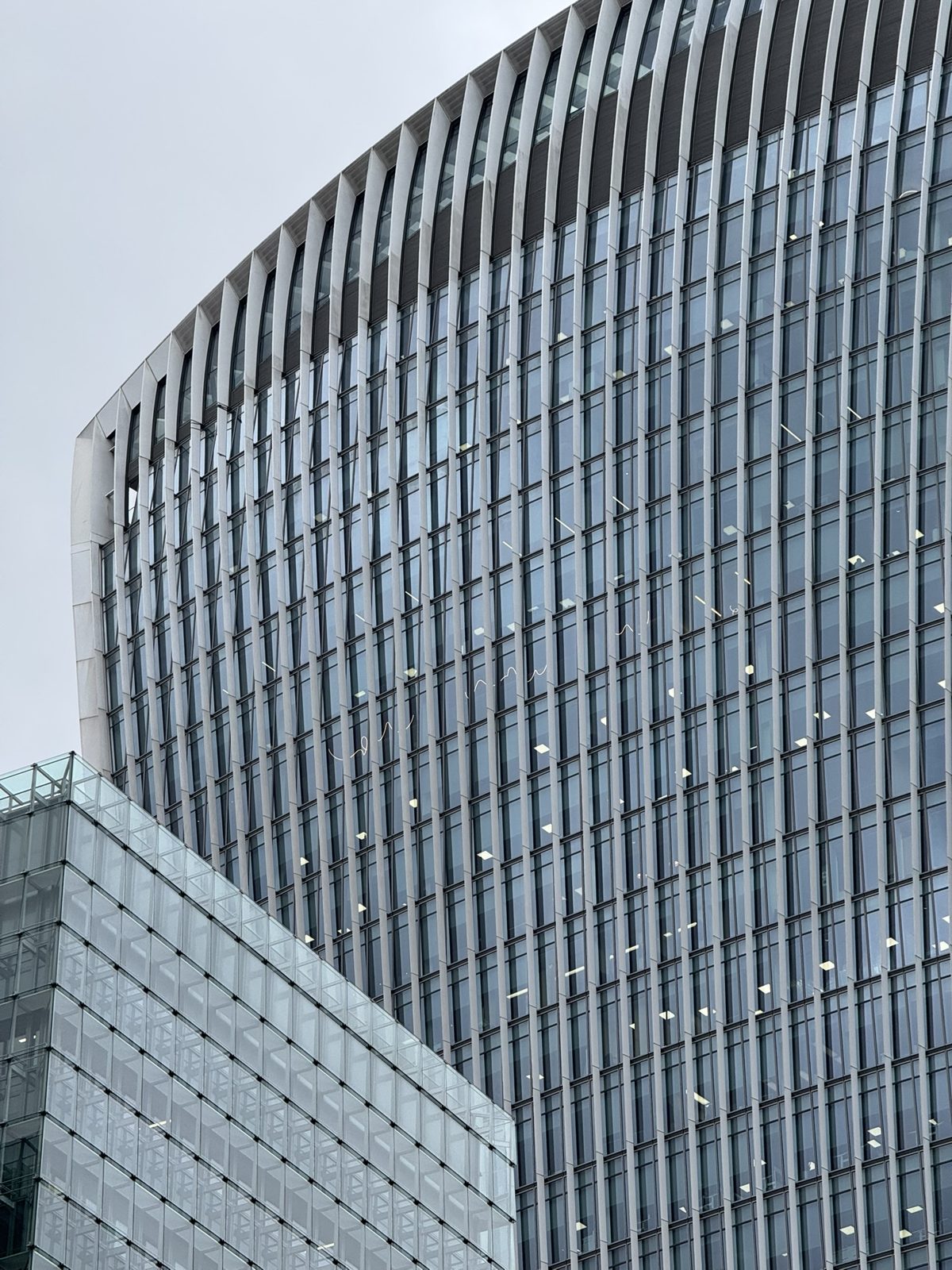A curved glass tower with vertical fins