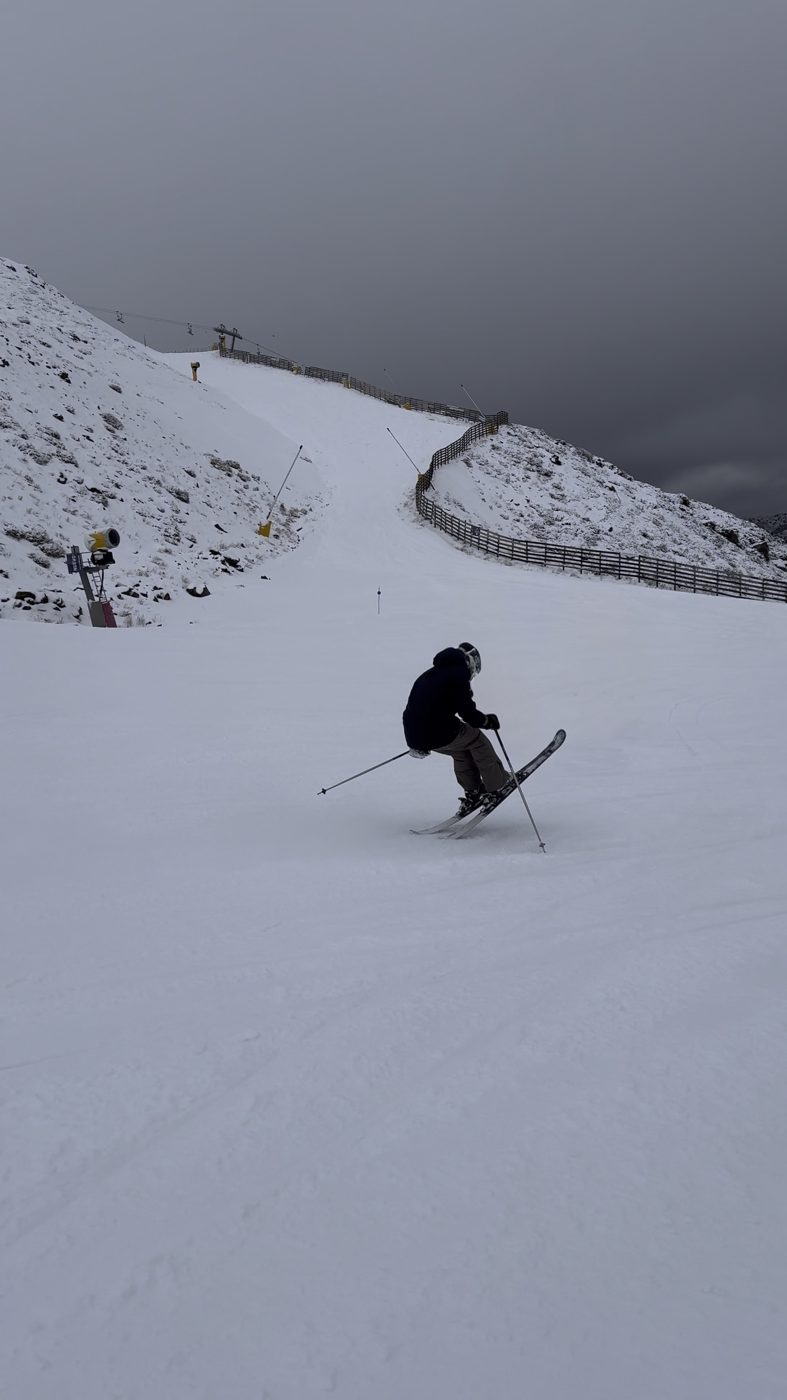 A lone skier carving down an empty, fog-bound slope